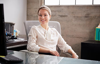 Smiling woman sitting at her office desk.