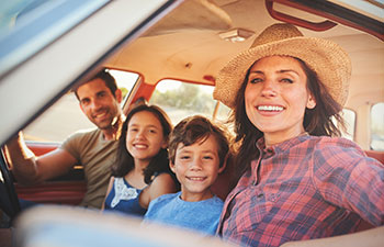 Happy family of four in the car.