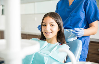 Portair of smilling teenage girl on dental chair. Orthodontic treatment in Marietta.